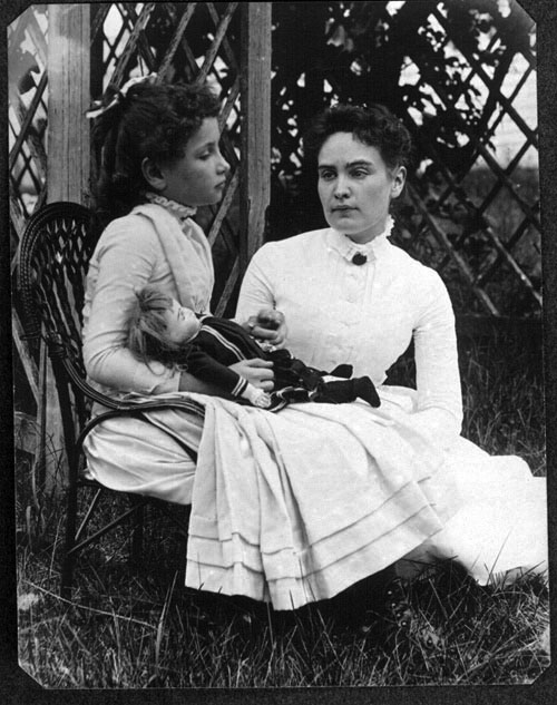Anne Sullivan Macy and Helen Keller are pictured in an old black and white photo in a garden